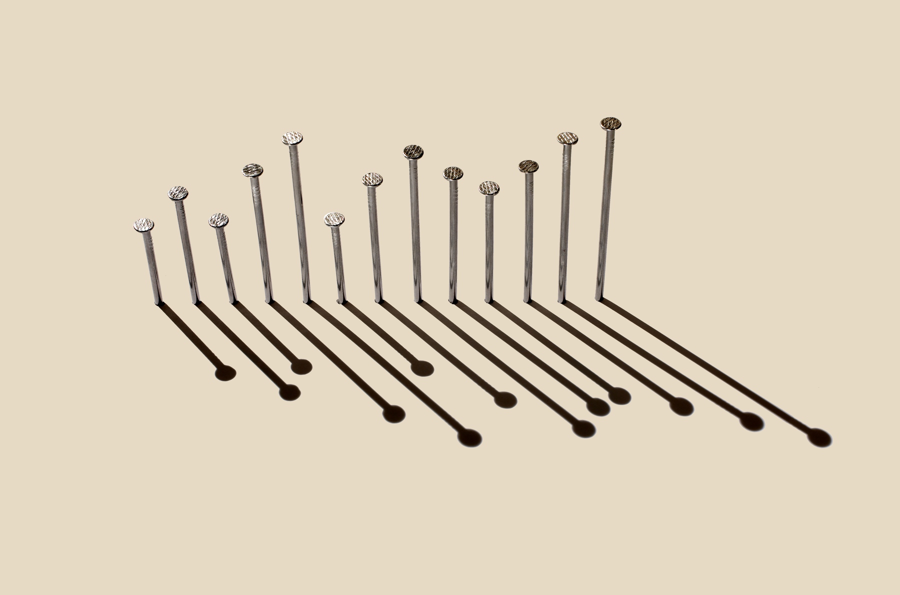 Row of nails in different length on a board arranged as bar chart
