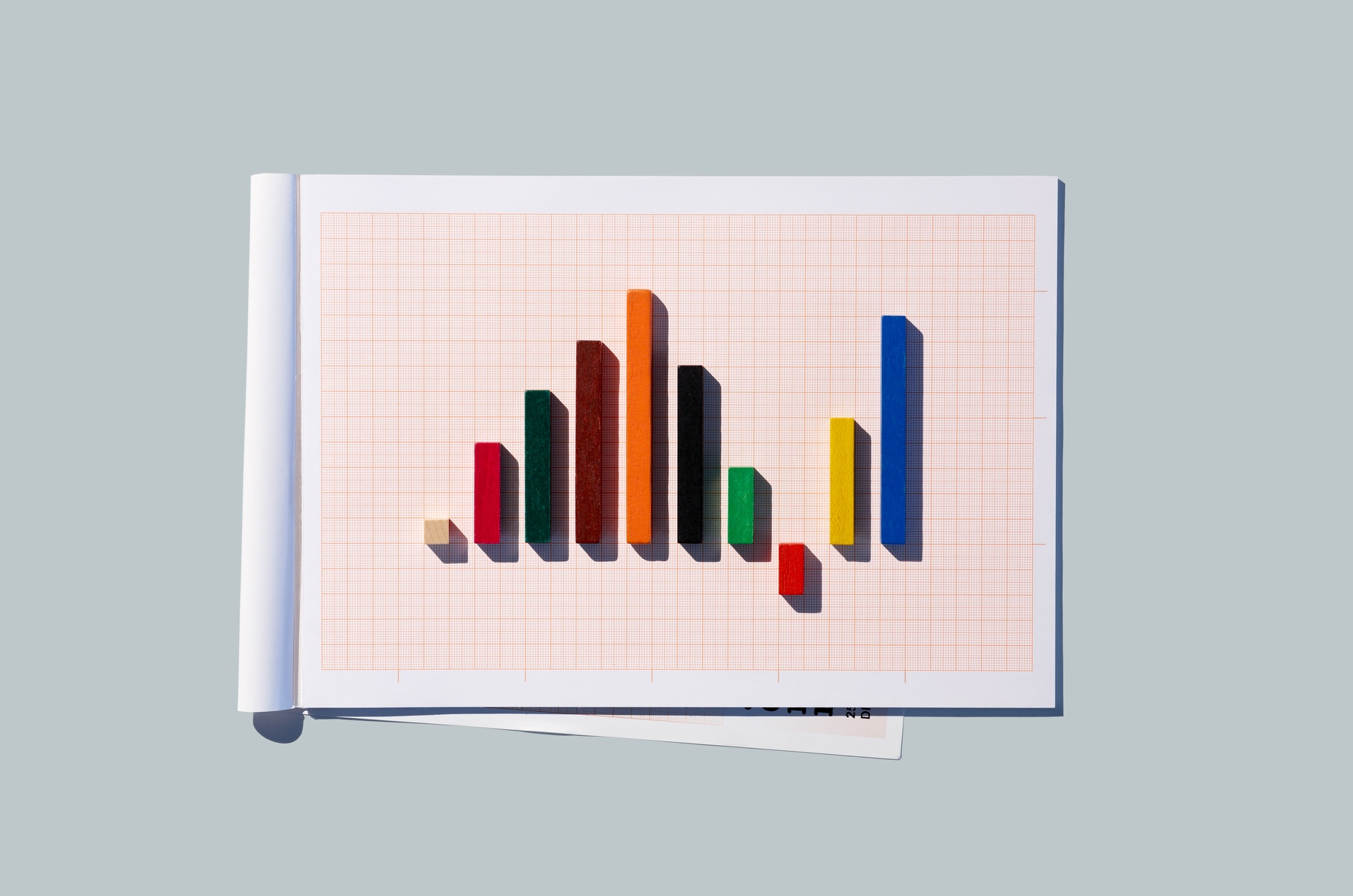 Row of multi colored rods on graph paper arranged as bar chart